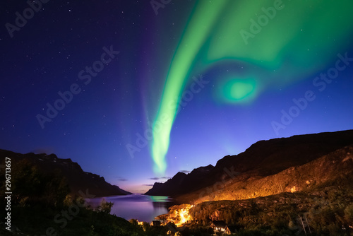 Beautiful autumn aurora borealis above fjord and mountains. Northern ligths and sunset at twilight. Multi colored  vibrant. Ersfjordbotn  Tromso  Norway.