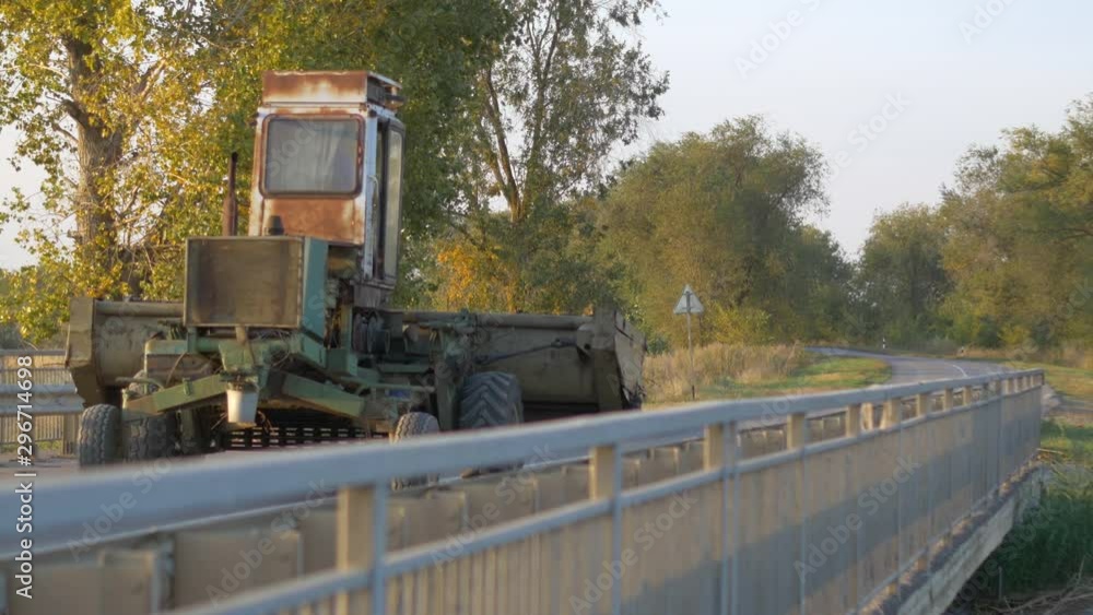 An old combine harvester rides on a bridge An old combine harvester rides on a bridge