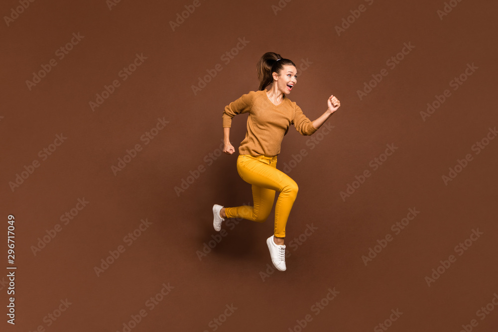 Full length body size photo of cheerful sweet pretty cute nice charming girl urgent for sales and discounted goods wearing yellow pants trousers isolated over brown pastel color background Full length body size photo of cheerful sweet pretty cute nice charming girl urgent for sales and discounted goods wearing yellow pants trousers isolated over brown pastel color background