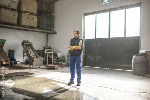 Posing woman stands in factory warehouse behind the door