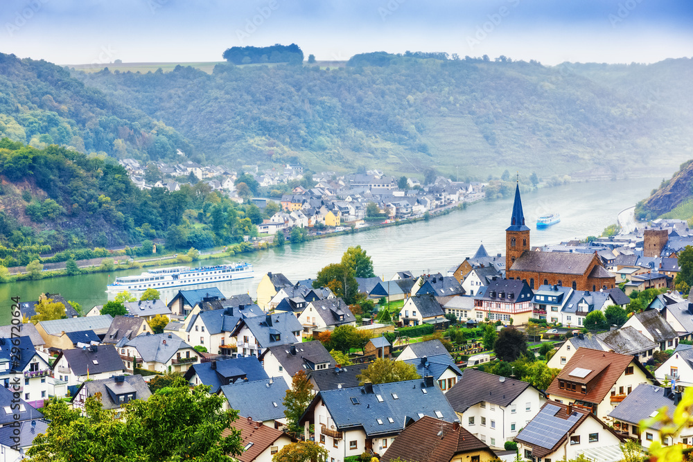 Fototapeta premium Germany, Europe. Traditional Panorama of Moselle river valley, view of towns Alken and Kattenes. Nearby Thurant Castle on hill top. Picturesque seasonal autumnal landscape of German countryside.