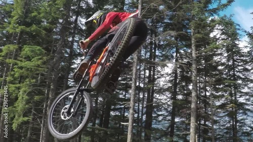close up of mountain bike rider jumping over large jump photo