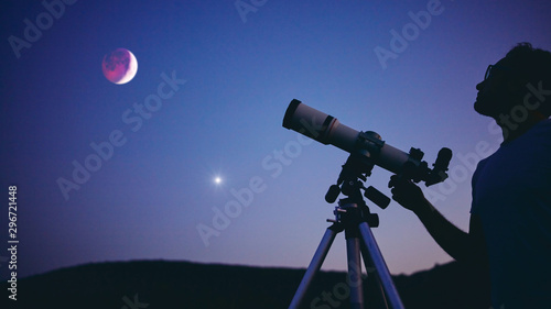 Fényképezés Astronomer with a telescope watching at the stars and Moon