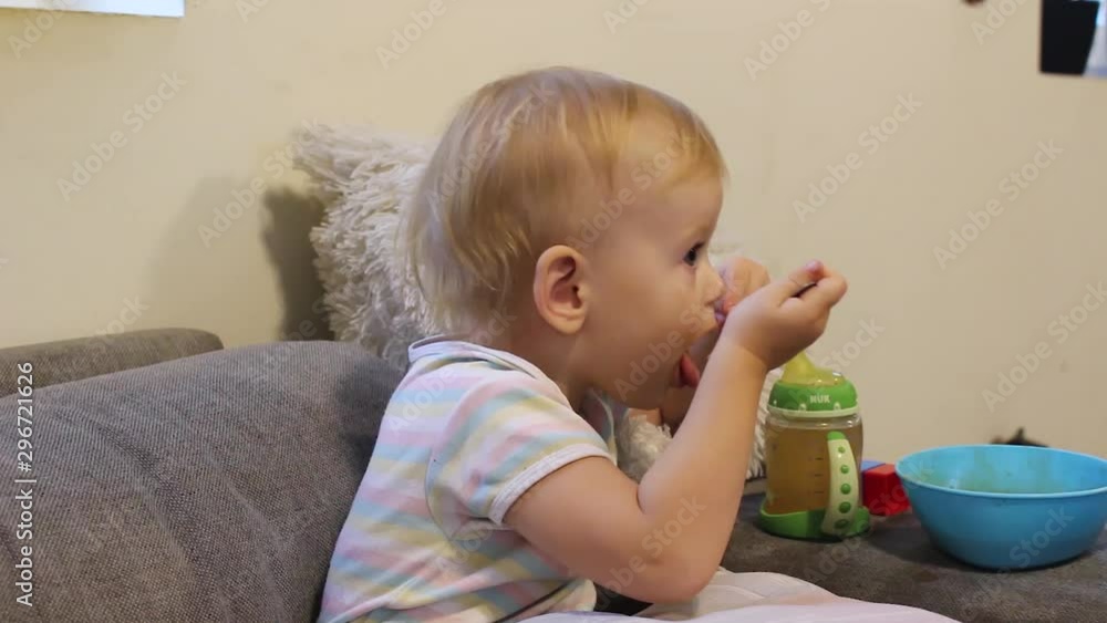 Little girl eating soup on the couch Little girl eating soup on the couch