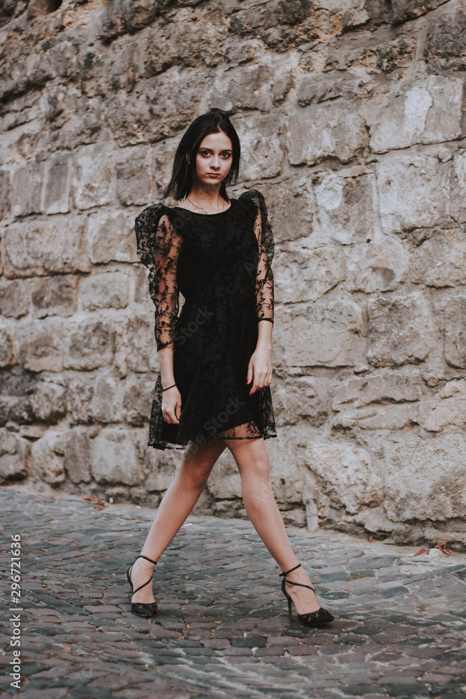 Black-haired girl. Black lace dress. Model shooting. Fashion and style.