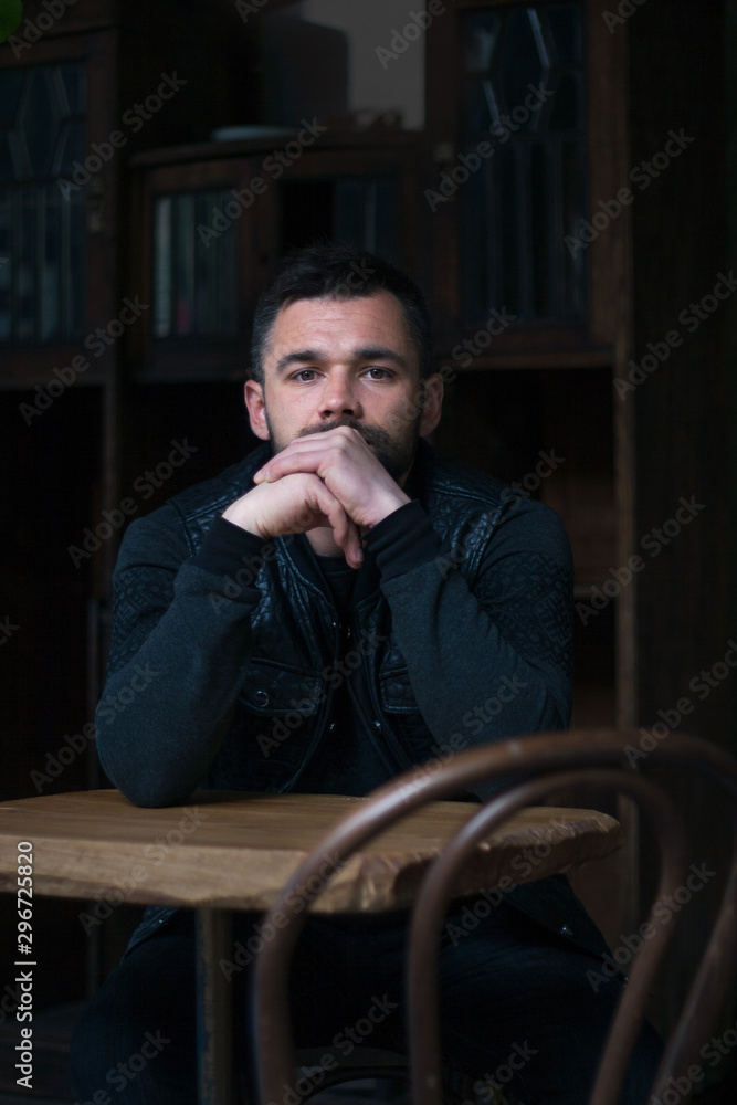 Portrait of a bearded young man in the interior.