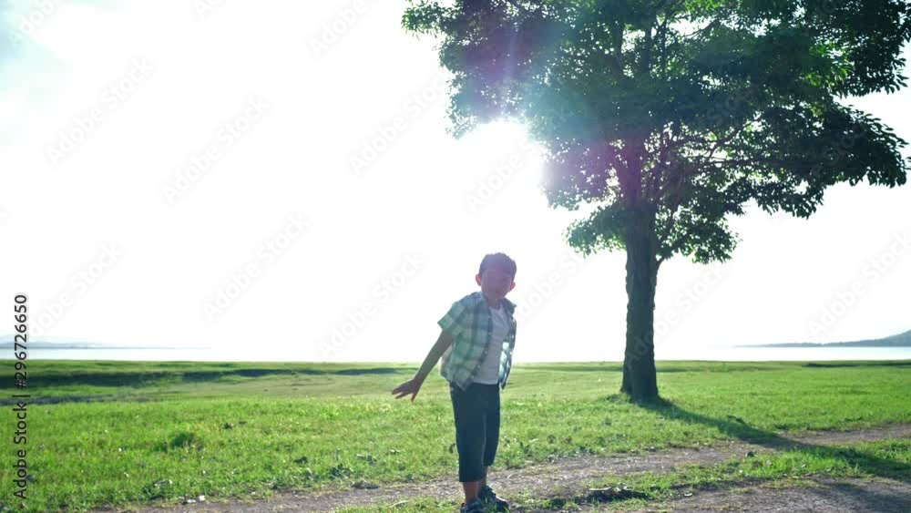 Happy Asian Child boy are throwing playing airplane simulate in the nature, trees and grasslands outdoors that has sunlight in the evening. Happiness holiday Slow Motion Happy Asian Child boy are throwing playing airplane simulate in the nature, trees and grasslands outdoors that has sunlight in the evening. Happiness holiday Slow Motion
