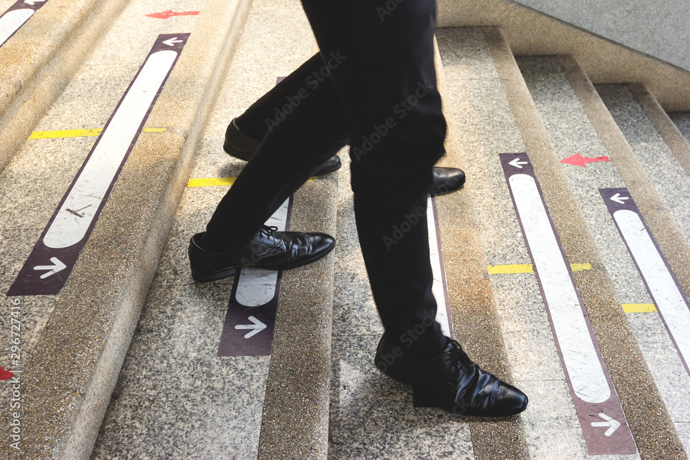 Obraz premium businessman legs walking down the stairs