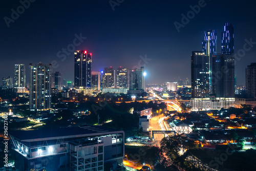 Johor Bahru, Malaysia, at night. Malaysian city with traffic on highway and modern business buildings and hotels in downtown. Scenic urban skyline and cityscape. Aerial view. photo