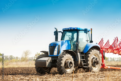 The tractor plows the field, cultivates the soil for sowing grain. The concept of agriculture and agricultural machinery.