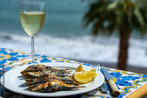 Espeto, Malaga style fish on stick barbecue prepared on olive tree firewoods and white wine photo