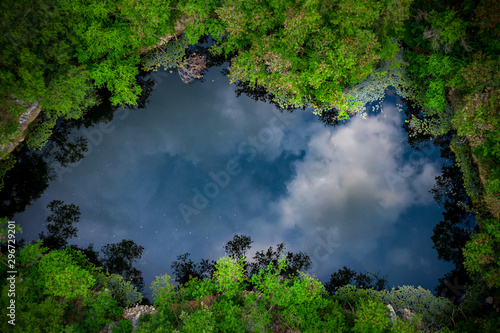 Aerial view of round shaped pond in autumn forest