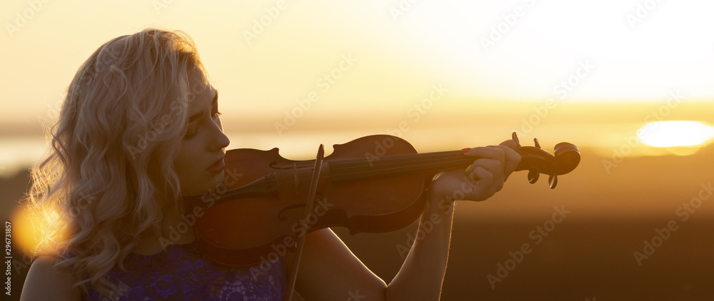 romantic portrait of girl playing violin at sunset in field, woman ...