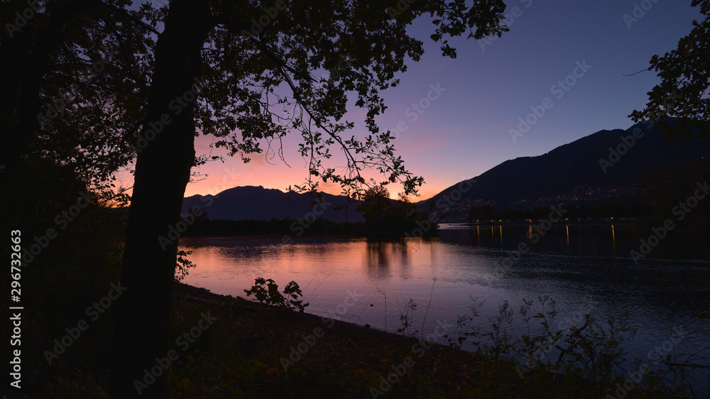 Tramonto sul lago con luce riflessa viola e rosa