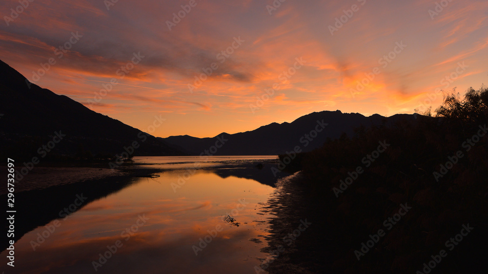 Favoloso tramonto sul lago, cielo arancione e giallo Favoloso tramonto sul lago, cielo arancione e giallo