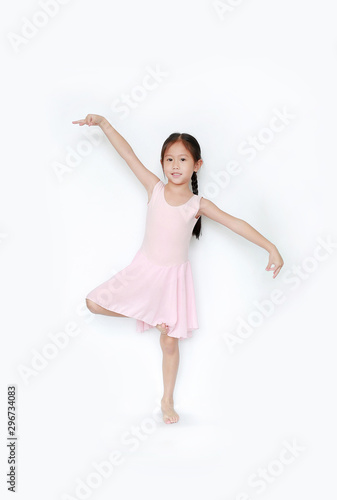 Beautiful little Asian child girl in pink tutu skirt dancing over white background. Children is studying ballet.