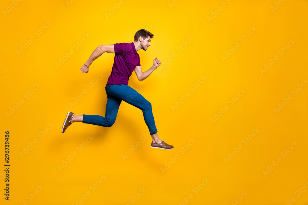 Full length body size side profile photo of fast quick handsome man wearing blue pants trousers footwear running jumping to empty space isolated over vivid color background