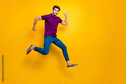 Full length body size turned photo of surprised man running as fast as he can towards shopping mall to come for sales on time wearing blue pants trousers shoes isolated vivid color background