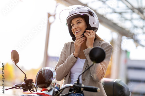 Woman on scooter tightens helmet photo