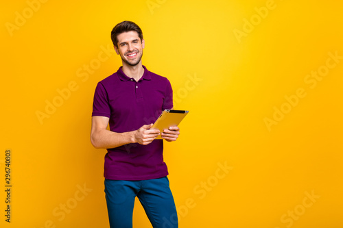 Portrait of his he nice attractive cheerful cheery content guy using digital ebook app browsing web wi-fi isolated over bright vivid shine vibrant yellow color background