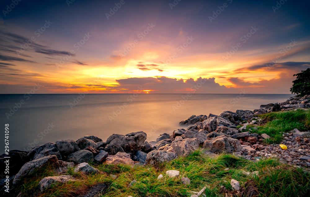 Rocks on stone beach at sunset. Beautiful beach sunset sky. Twilight sea and sky. Tropical sea at dusk. Dramatic sky and clouds. Calm and relax life. Nature landscape. Tranquil and peaceful concept.