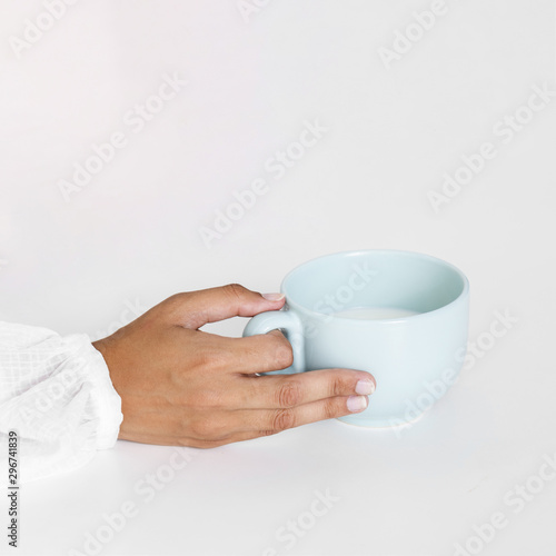 Close-up hand holding ceramic mug