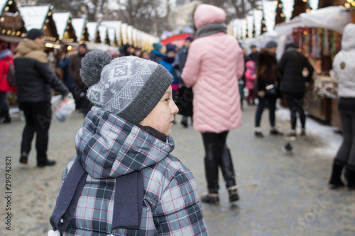 little boy with his back to the fair,little boy looked at his back while standing at the Christmas market in winter