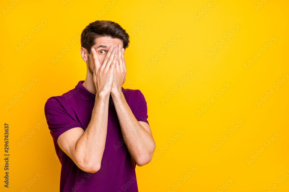 Portrait of his he nice attractive scared guy wearing violet shirt hiding face in palms peeking isolated on bright vivid shine vibrant yellow color background Portrait of his he nice attractive scared guy wearing violet shirt hiding face in palms peeking isolated on bright vivid shine vibrant yellow color background
