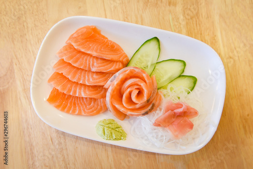 Japanese food raw sashimi salmon fillet with vegetable cucumber and wasabi in the restaurant / Salmon sashimi menu set Japanese cuisine fresh ingredients on plate