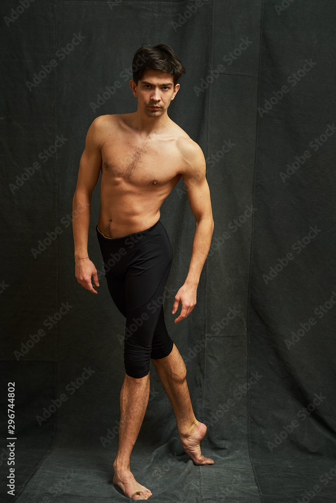Obraz premium Male ballet dancer posing in studio on a black background