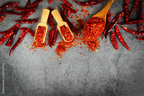 Fototapeta Naklejka Na Ścianę i Meble -  cayenne pepper on wooden spoon spices and dried chilli peppers background - group of red hot chilli powder on black plate top view ingredients table asian food spicy in thailand