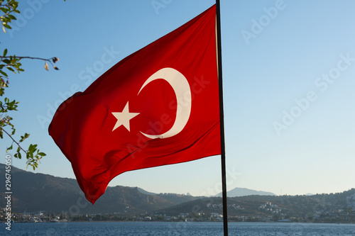 Turkish flag close up. The Turkish flag develops against the blue sky of mountains and the sea.