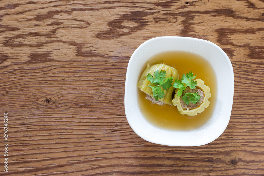 Stuffed bitter gourd soup with seasoned minced pork on wood background Stuffed bitter gourd soup with seasoned minced pork on wood background