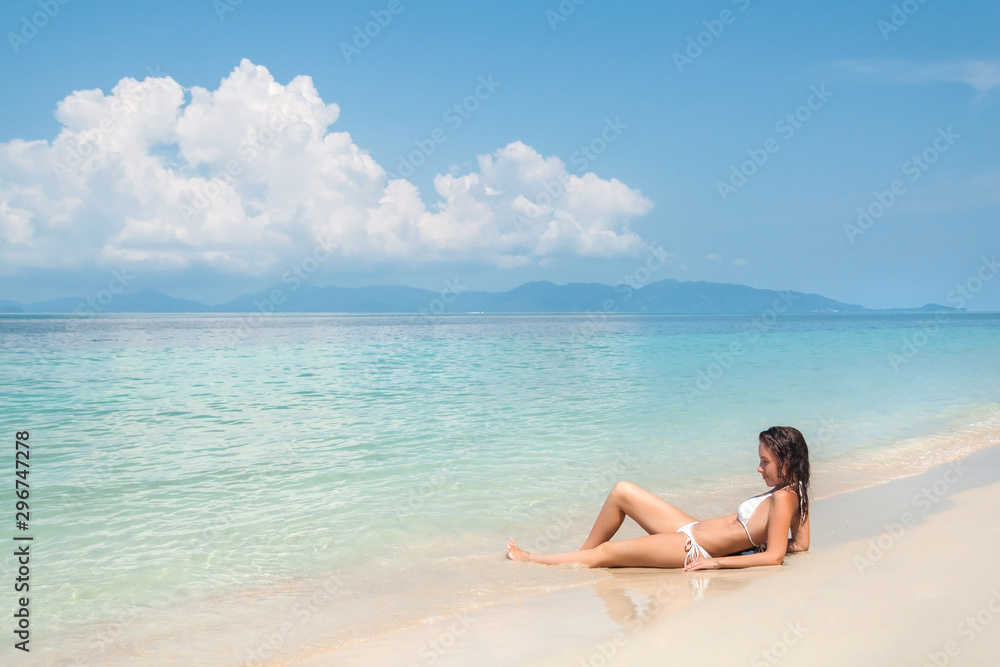 Young woman lying on a tropical white sand beach Young woman lying on a tropical white sand beach