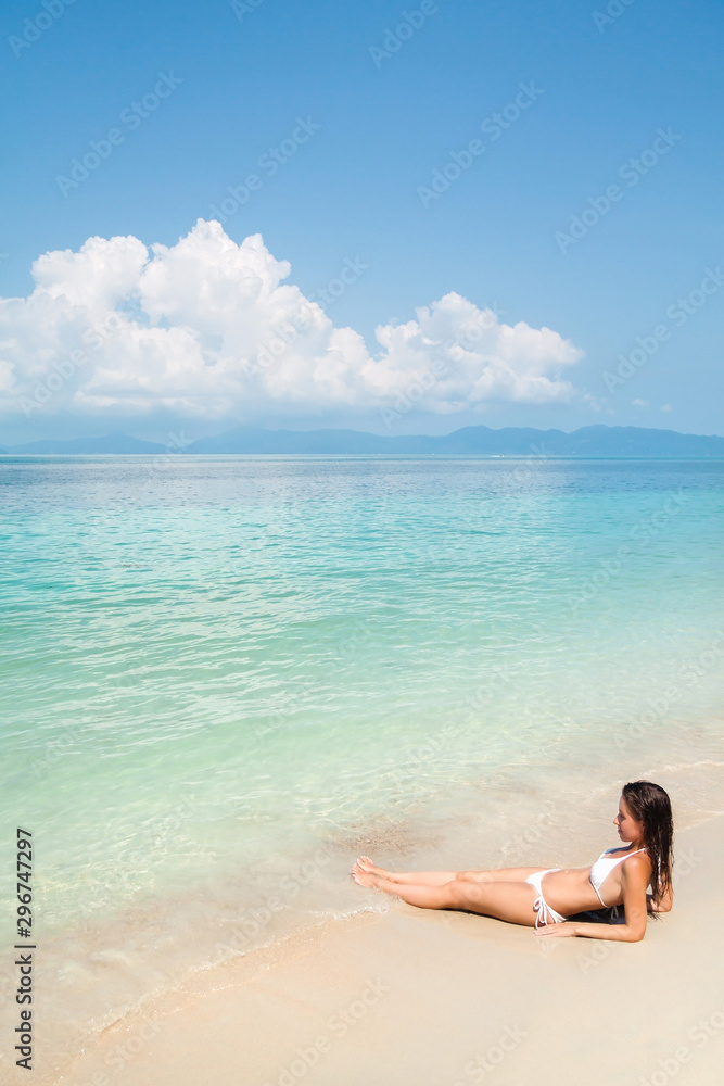 Young woman lying on a tropical white sand beach Young woman lying on a tropical white sand beach