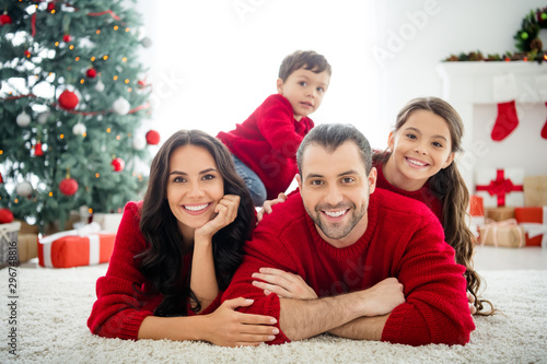 Portrait of four nice attractive sweet peaceful cheerful affectionate big full foster family mom dad celebrating newyear december tradition enjoying rest relax light white interior living-room
