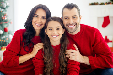 Close-up portrait of three nice attractive lovely sweet adorable kind careful charming cheerful cheery adopted foster family spending winter December leisure in light white interior living-room indoor