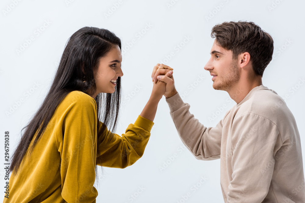 side view of handsome man and happy woman holding hands isolated on white side view of handsome man and happy woman holding hands isolated on white