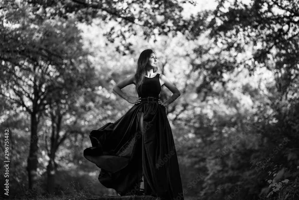 Woman is posing in forest. Black and white photo