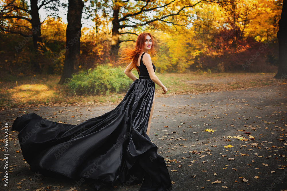 Naklejka premium Woman in long dress runs through a forest