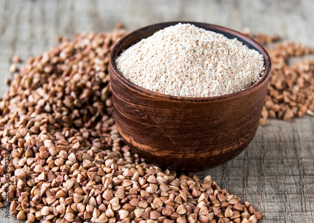 Buckwheat flour in a bowl near the buckwheat grain. A pile of buckwheat flour. Buckwheat flour in a bowl near the buckwheat grain. A pile of buckwheat flour.
