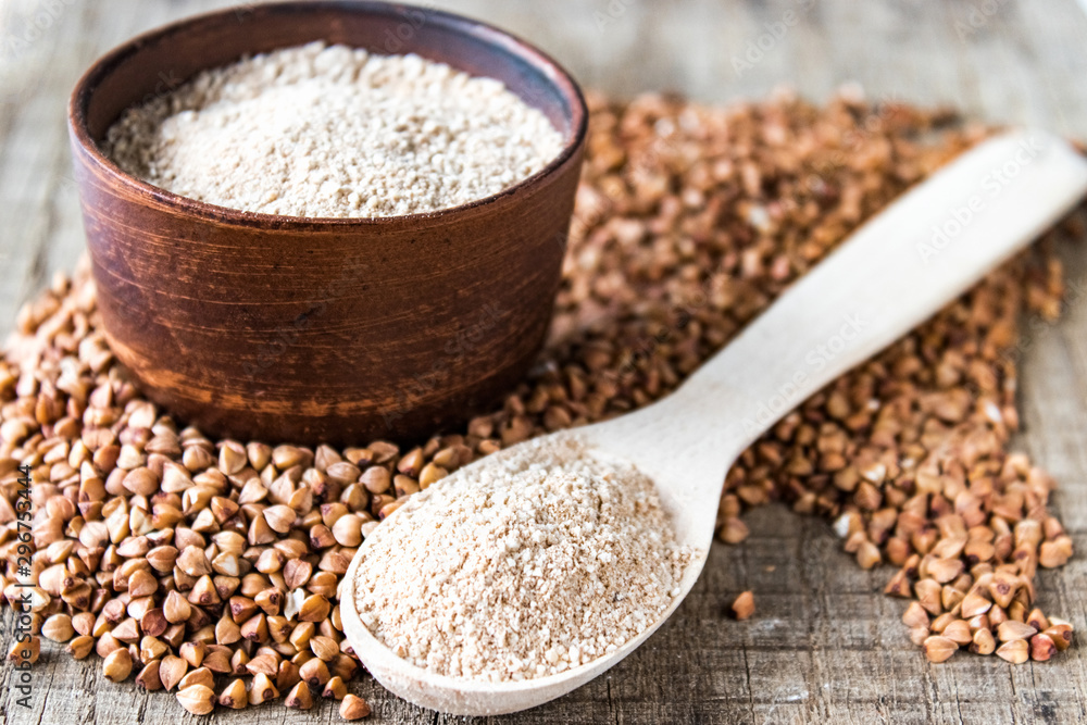 Buckwheat flour in a bowl near the buckwheat grain and a spoon with flour. A pile of buckwheat flour. Buckwheat flour in a bowl near the buckwheat grain and a spoon with flour. A pile of buckwheat flour.