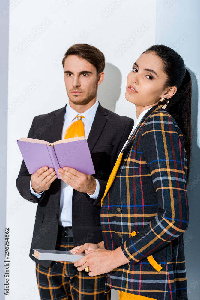 attractive girl with book near stylish man on white attractive girl with book near stylish man on white
