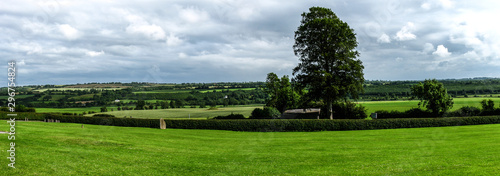 Scenic view of rolling countryside green farm fields with sheep, cow in a background on green grass in New Grange, County Meath