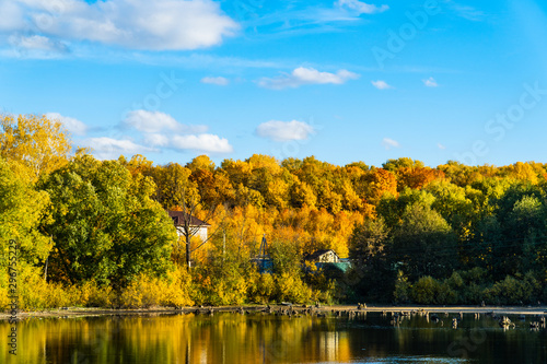 autumn landscape with blue sky and a small lake