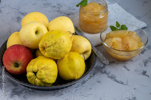 The fruits of apples and quinces. They differ in their useful properties. Suitable for food in baked, boiled form. Have a yellow color. Near jam of these fruits. Horizontal location. Copy space. 