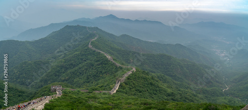 Great Wall of China with a green trees in a background. Panoramic view during foggy weather on summer time photo