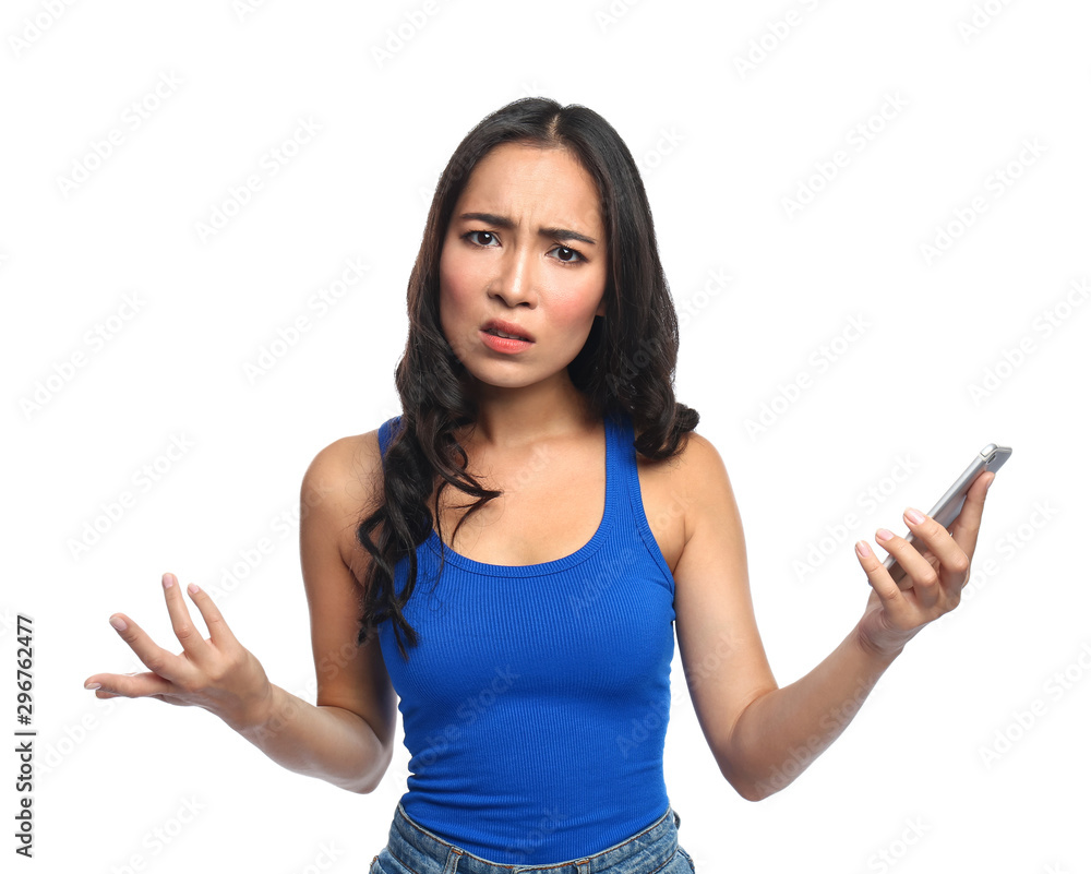 Displeased Asian woman with mobile phone on white background Displeased Asian woman with mobile phone on white background