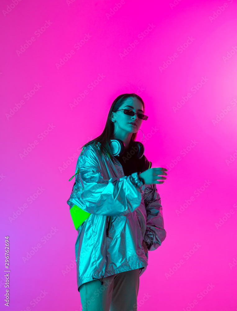 Young stylish girl dancing in the Studio on a colored neon background. Music poster design. Young stylish girl dancing in the Studio on a colored neon background. Music poster design.