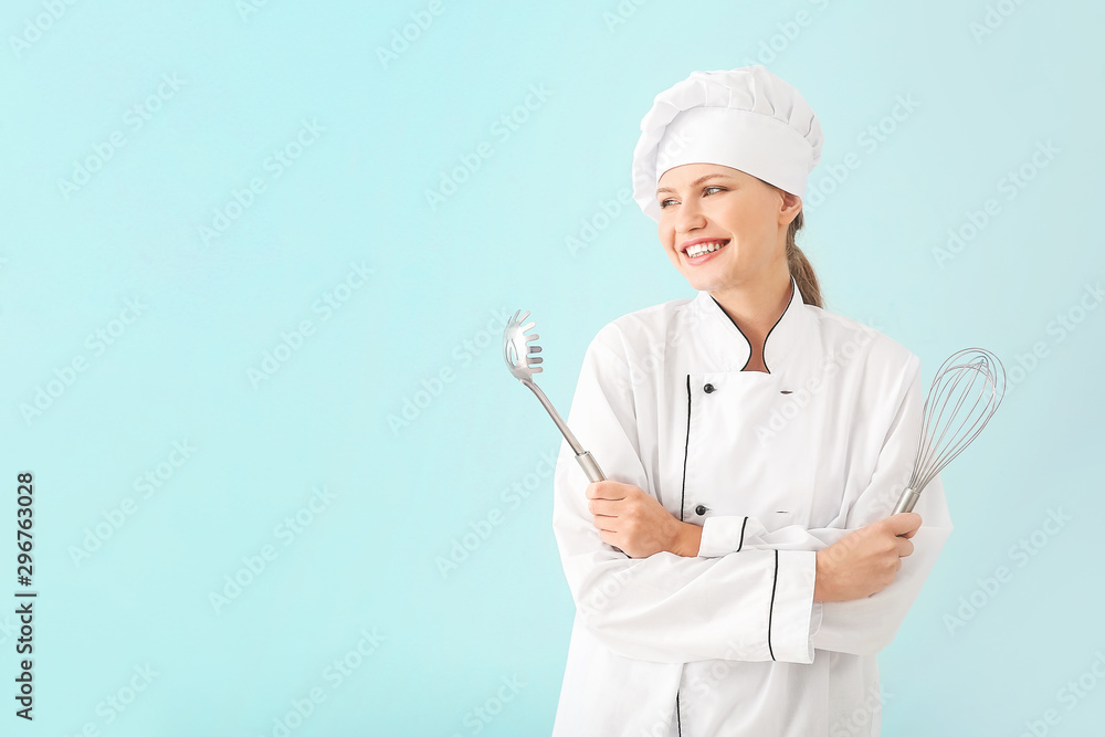 Beautiful female chef with kitchenware on light background